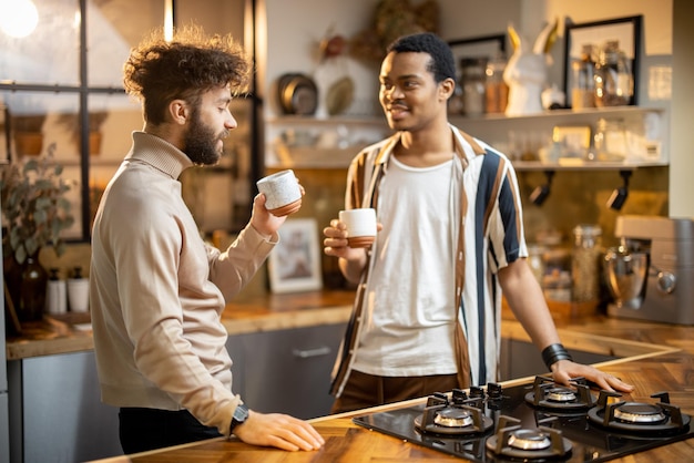 Dos hombres hablando y bebiendo café en la cocina de casa