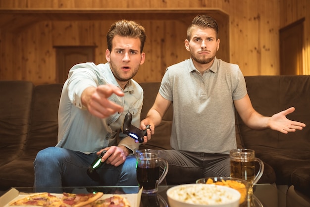 Los dos hombres hacen un gesto cerca de la mesa con una comida.