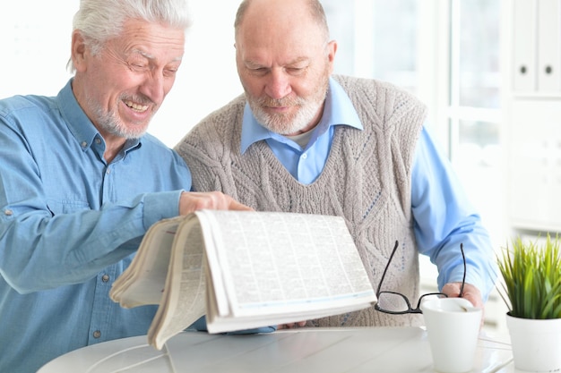 Dos hombres mayores leyendo el periódico