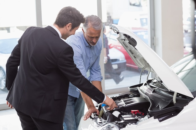 Dos hombres mirando el motor de un automóvil