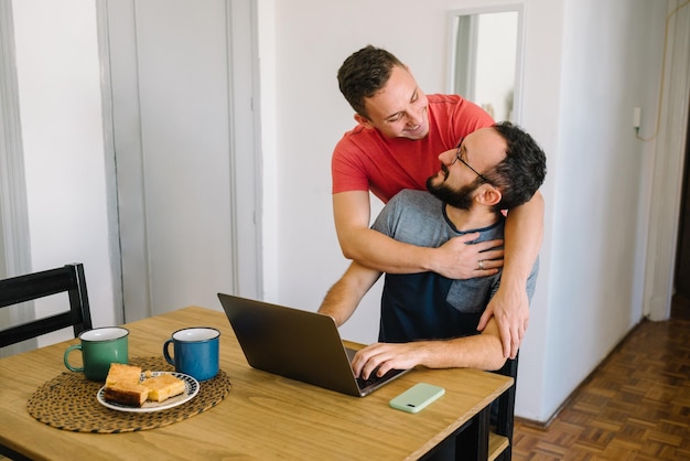 Dos hombres mirándose el uno al otro con una computadora portátil