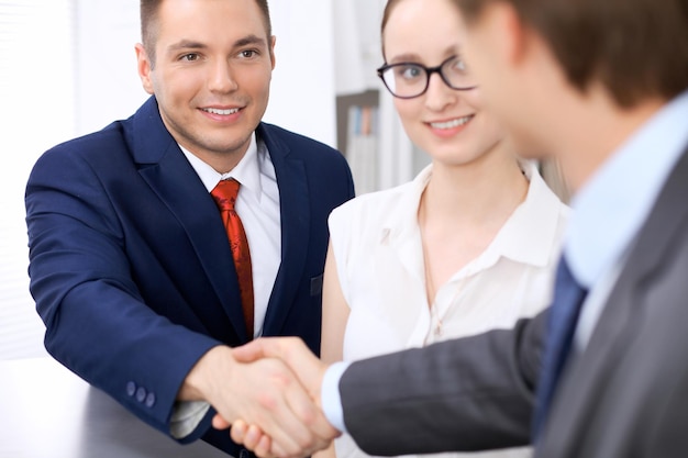 Dos hombres de negocios dándose la mano terminando la reunión.