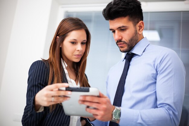 Foto dos hombres de negocios discutiendo mientras miran una tableta