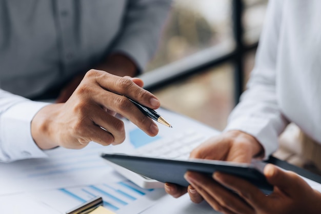 Dos hombres de negocios están haciendo una lluvia de ideas y revisando los documentos financieros de la empresa que el departamento de finanzas ha resumido que son socios comerciales Concepto de administración empresarial