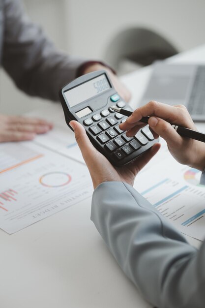 Dos hombres de negocios están haciendo una lluvia de ideas y revisando los documentos financieros de la empresa que el departamento de finanzas ha resumido que son socios comerciales Concepto de administración empresarial