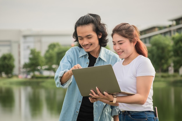 Dos hombres de negocios felices usando tecnología informática al aire libre