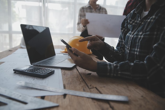 Dos hombres de negocios ingeniero del sitio de construcción Objetos de ingeniería en el lugar de trabajo con socios que interactúan en el fondo