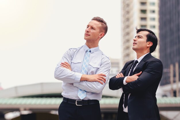 Dos hombres de negocios de pie mirando en la ciudad