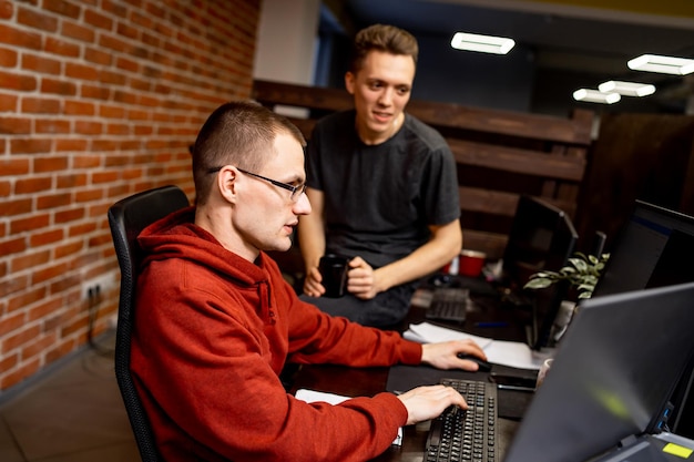 Dos hombres que trabajan en una oficina moderna Logrando los mejores resultados Dos jóvenes confiados están discutiendo planes de negocios