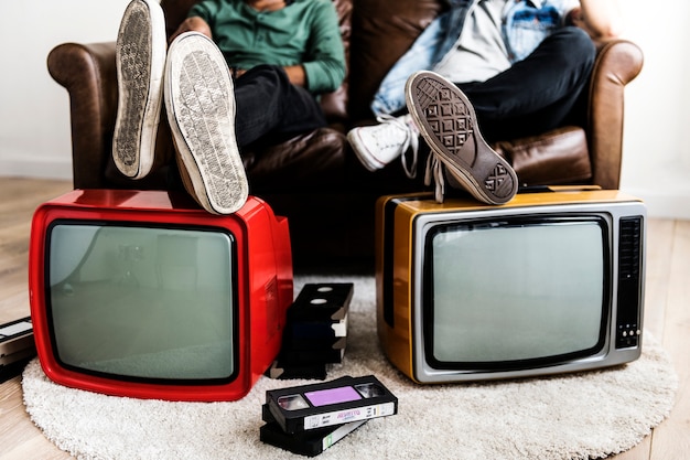 Foto dos hombres sentados y dos televisores retro