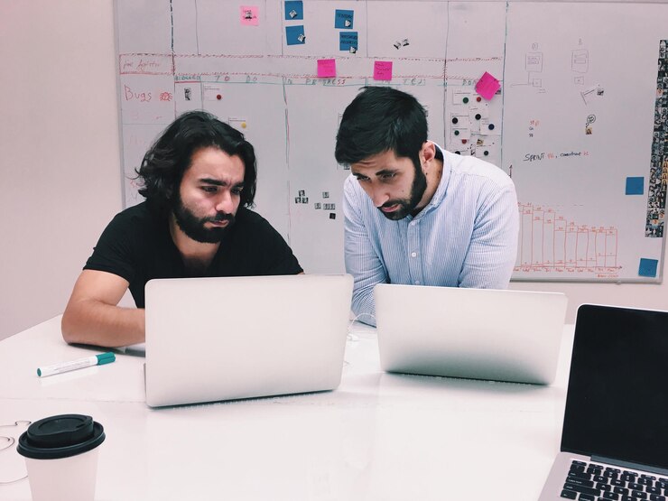 Foto dos hombres trabajando en una computadora portátil
