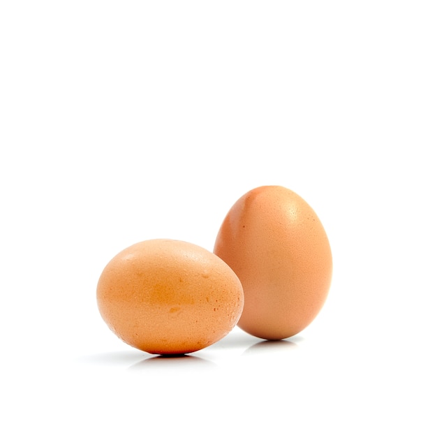 Dos huevos de gallina frescos aislados contra un fondo blanco.