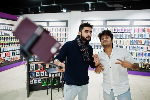 Foto dos indios mans cliente comprador en teléfono móvil haciendo selfie por monopod stick concepto de tecnologías y pueblos del sur de asia tienda de teléfonos móviles