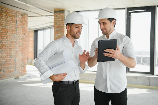 Dos ingenieros civiles o arquitectos inspeccionan la construcción de la casa