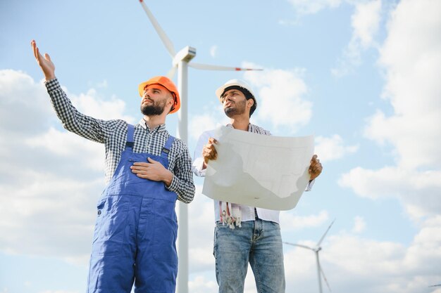 Dos ingenieros discutiendo contra turbinas en parques eólicos