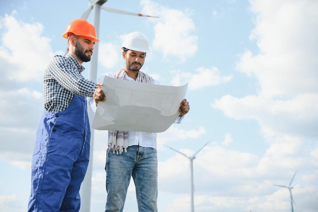 Dos ingenieros discutiendo contra turbinas en parques eólicos