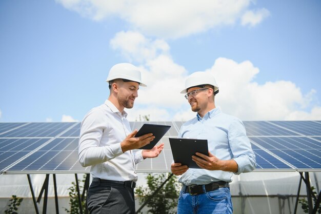 Dos ingenieros están realizando una inspección al aire libre de paneles solares fotovoltaicos