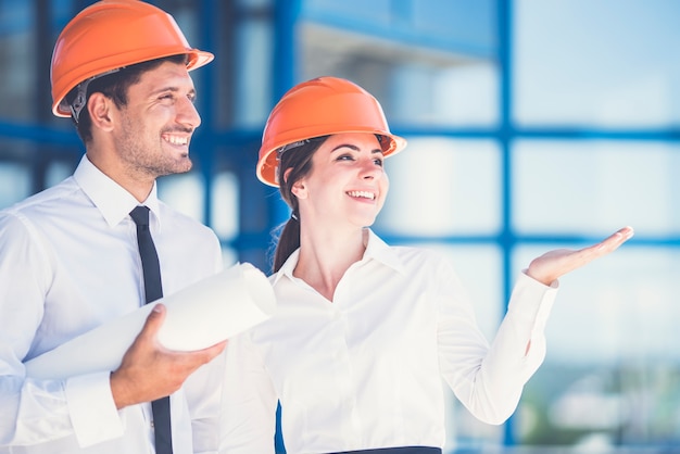 Los dos ingenieros con un gesto de papel en el fondo del edificio