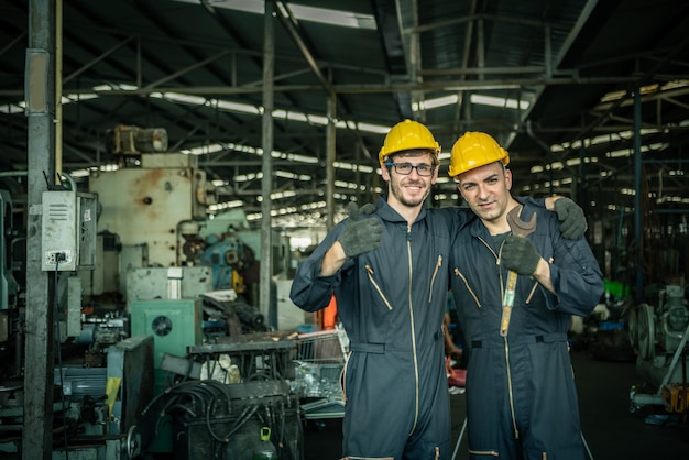 Foto dos ingenieros masculinos están trabajando en máquinas industriales concepto industria