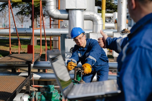 Dos ingenieros que trabajan dentro de la refinería de petróleo y gas