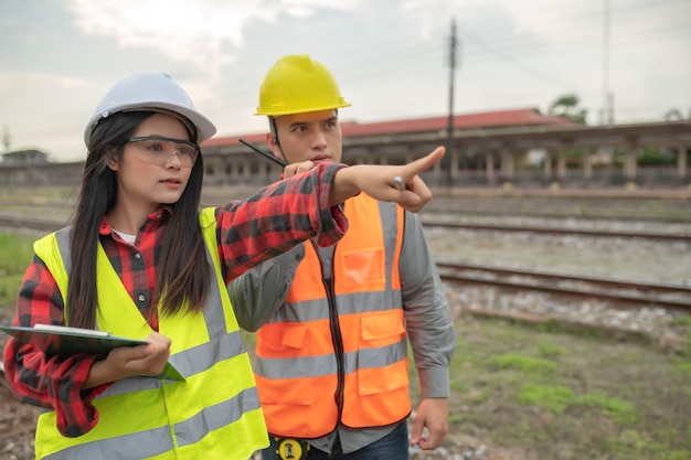 Dos ingenieros trabajando en la estación de trenTrabajar juntos felizmenteAyudarse mutuamente a analizar el problemaConsultar sobre las pautas de desarrollo