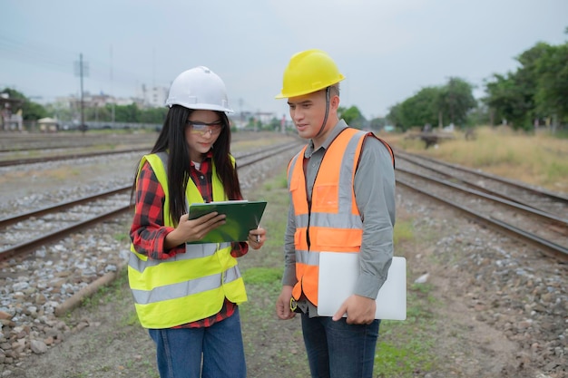 Dos ingenieros trabajando en la estación de trenTrabajar juntos felizmenteAyudarse mutuamente a analizar el problemaConsultar sobre las pautas de desarrollo