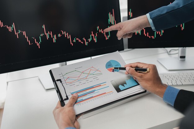Dos inversores en acciones con pantalla gráfica del mercado de valores análisis de fluctuación de acciones hombre de negocios negociando acciones para obtener ganancias pantalla gráfica de fluctuación del mercado de valores análisis de operaciones de ganancias