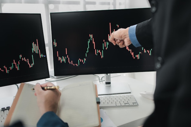 Dos inversores en acciones con pantalla gráfica del mercado de valores análisis de fluctuación de acciones hombre de negocios negociando acciones para obtener ganancias pantalla gráfica de fluctuación del mercado de valores análisis de operaciones de ganancias