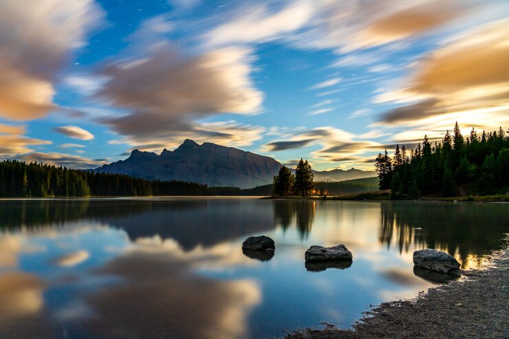 Dos Jack Lake al amanecer, cielo estrellado y coloridas nubes reflejadas en la superficie del agua.