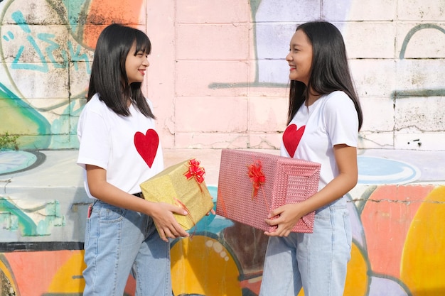 Dos joven feliz con caja de regalo en colores de fondo