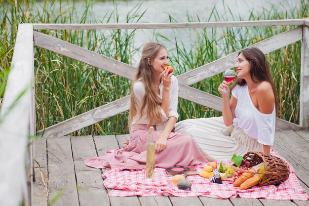 Dos jóvenes alegres hacen un picnic al aire libre en un día de verano.