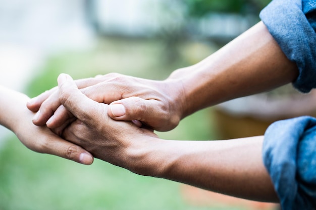 Foto dos jóvenes amantes cogidos de la mano con fondo borroso