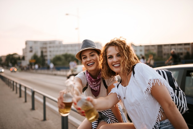 Dos jóvenes amigas disfrutando de bebidas en el verano.