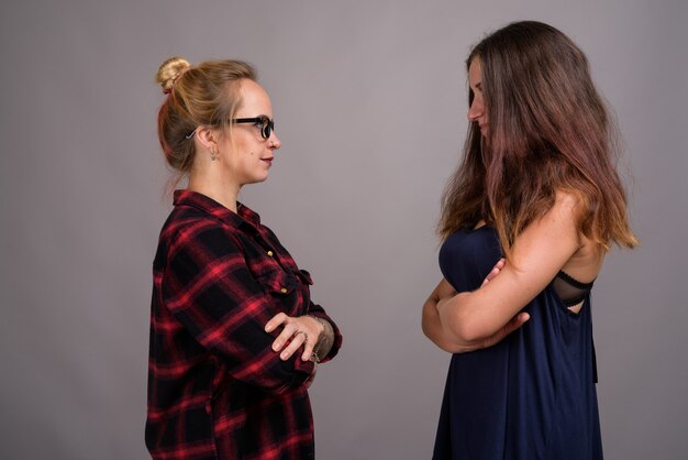 Dos jóvenes amigas hermosas juntas en gris