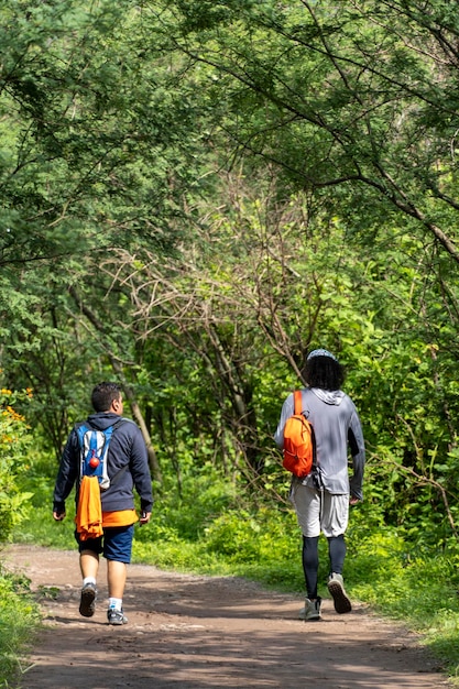 Dos jóvenes y amigos descendiendo en el barranco vegetación y árboles barranco huentitan guadalajara méxico