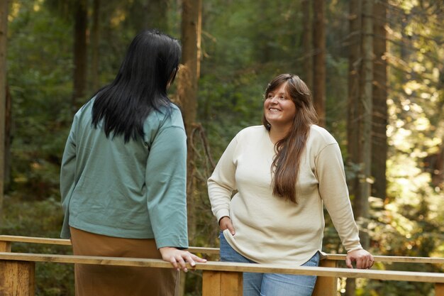 Dos jóvenes amigos hablando entre sí durante su paseo por el bosque al aire libre