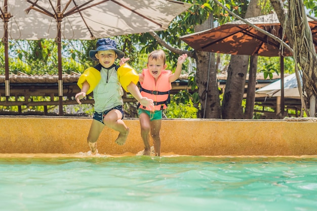 Dos jóvenes amigos saltando en la piscina