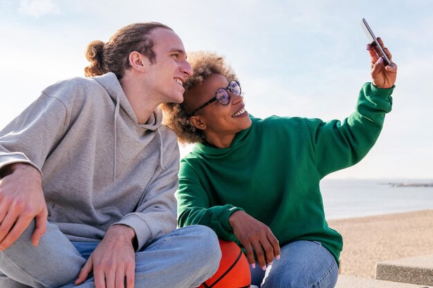 Dos jóvenes amigos sonriendo mientras se toman una selfie