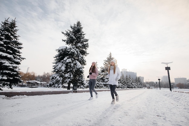 Dos jóvenes atléticas corriendo en el parque en un día soleado de invierno. Una forma de vida sana.