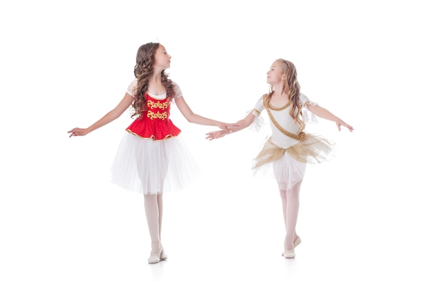 Foto dos jóvenes y bonitas bailarinas mirándose una a la otra.
