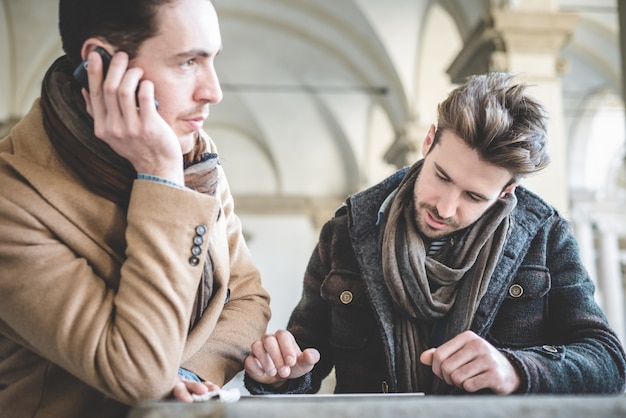 dos jóvenes empresarios guapos con tableta