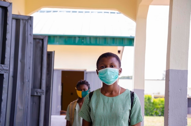 Dos jóvenes estudiantes africanos que usan mascarillas para evitar que broten en la sociedad como el regreso a la escuela.