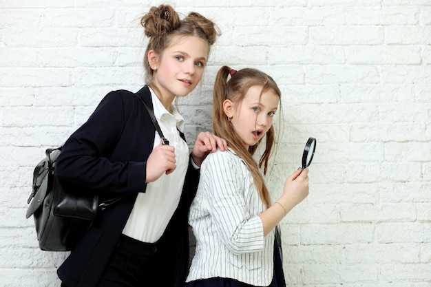 Dos jóvenes hermosas chicas rubias en uniforme escolar están en el salón de clases