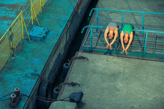 Dos jóvenes hermosas hermanas gemelas bailando ballet en la ciudad con traje de ballet danza sincronizada urbana