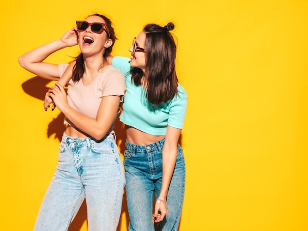 Dos jóvenes hermosas mujeres hipster rubias sonrientes en ropa de verano de moda Mujeres sexy despreocupadas posando en el estudio Modelos positivos divirtiéndose Alegre y feliz