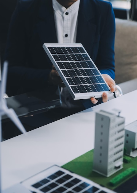 Dos jóvenes ingenieros expertos en la instalación de celdas solares Reuniones y discusión en el trabajo Planificación para instalar paneles solares fotovoltaicos en el techo de la sala de oficinas con plan de construcción de la fábrica