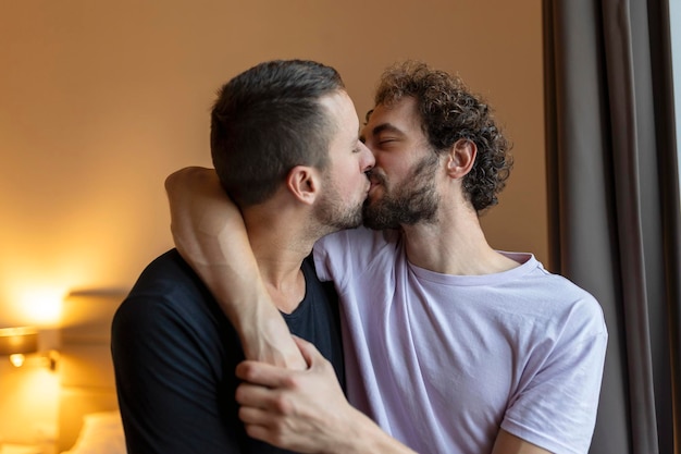 Dos jóvenes lgbtq pareja gay saliendo enamorados abrazándose disfrutando de un momento íntimo tierno y sensual juntos besándose con los ojos cerrados