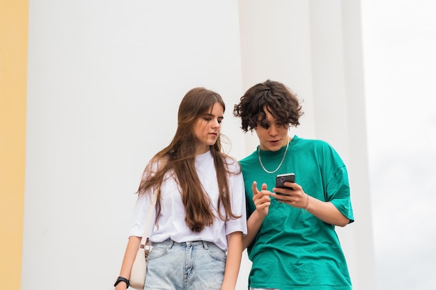 dos jóvenes miran el teléfono tal vez tratando de encontrar su camino