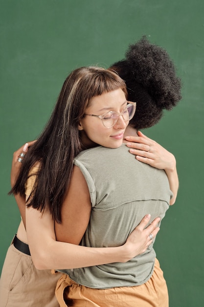 Dos jóvenes mujeres interculturales abrazándose
