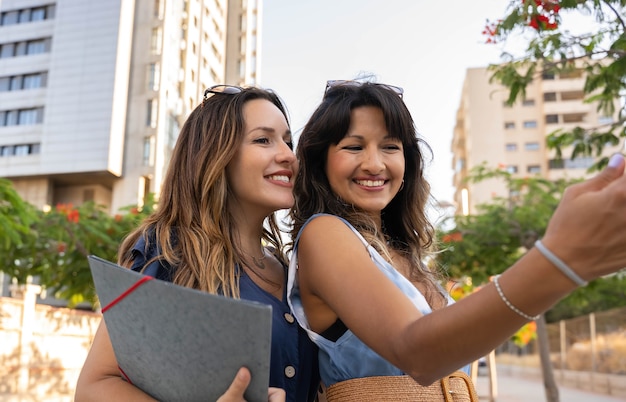 Dos jóvenes mujeres de negocios tomando una foto con el móvil